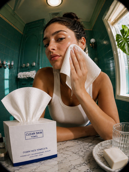 Woman drying face with disposable cotton face towel